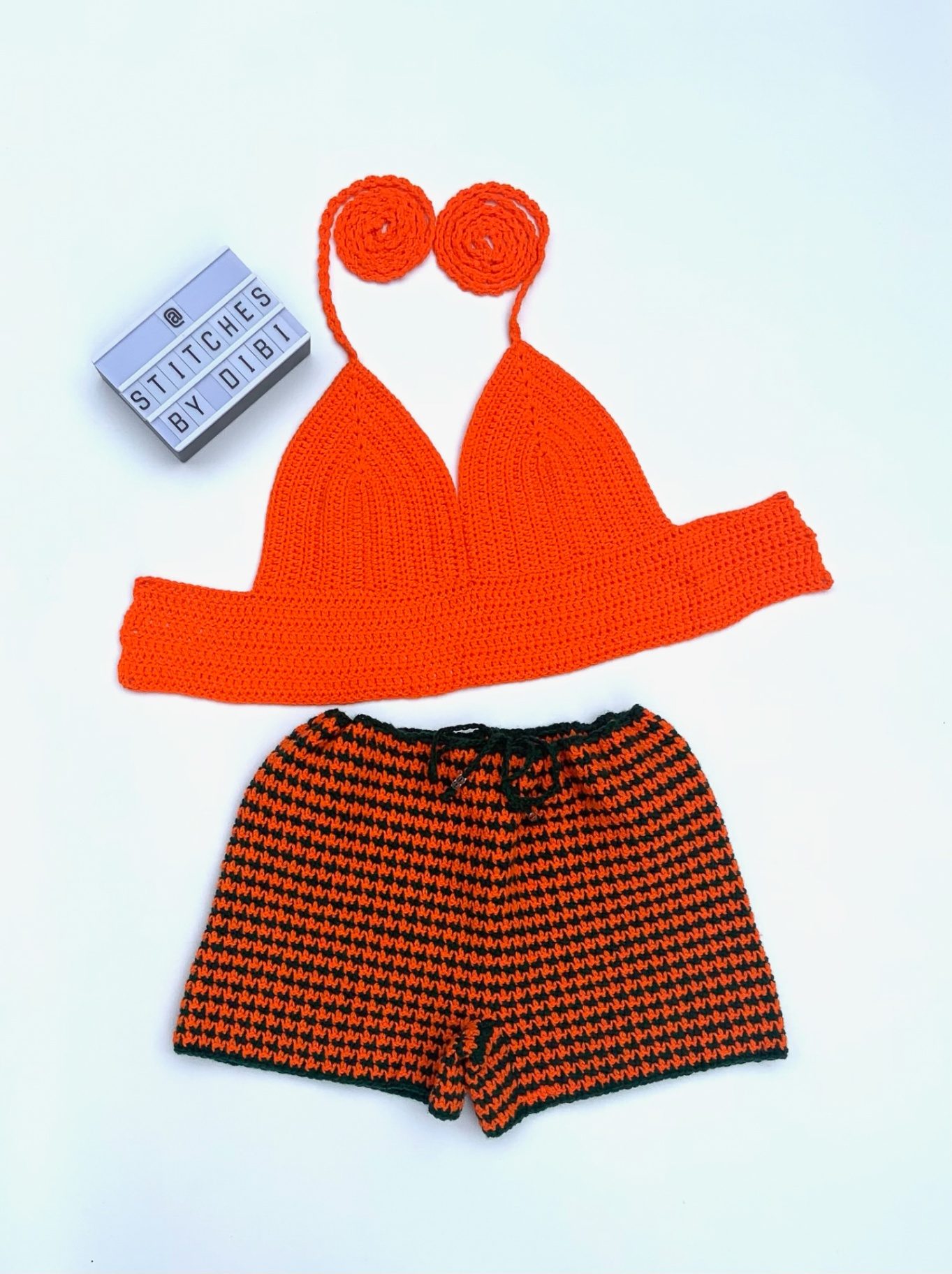 Neon orange halter bralette with matching orange and black houndstooth crochet shorts